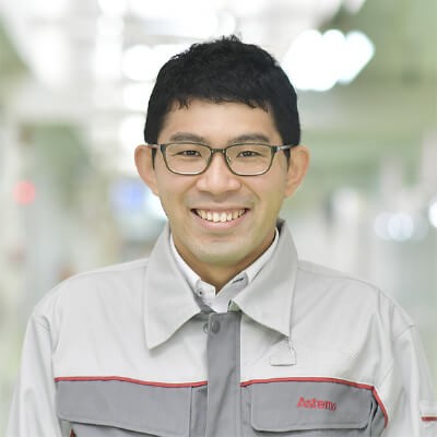 a person wearing glasses and a grey jacket