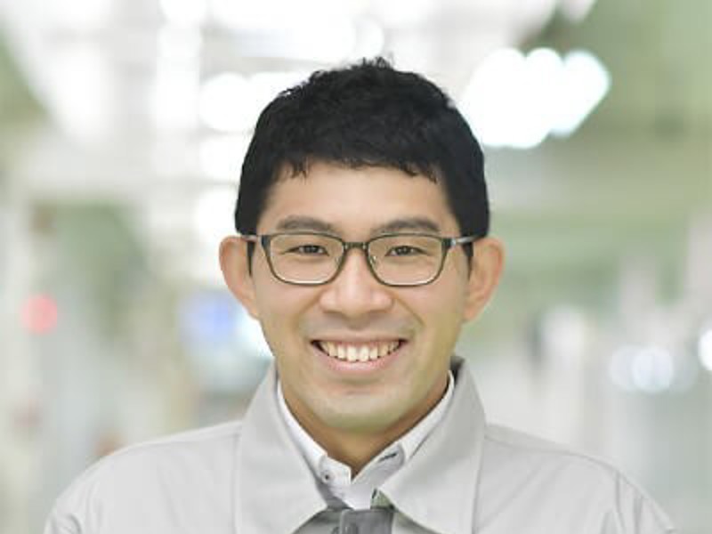 a person wearing glasses and a grey jacket