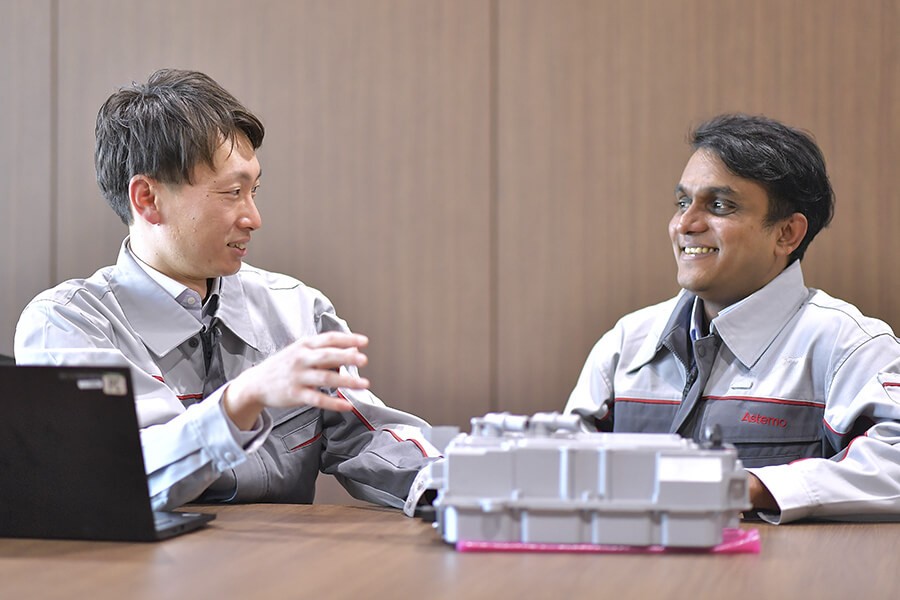 グレーのジャケットを着た数人の男性がテーブルに座っている