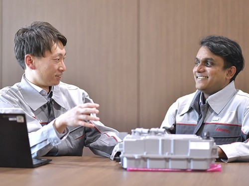 グレーのジャケットを着た数人の男性がテーブルに座っている