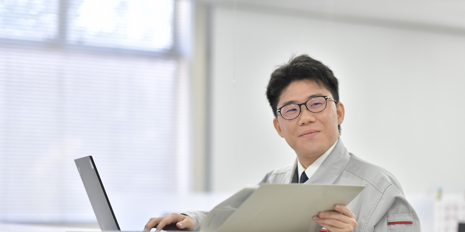 スーツとネクタイを着てファイルを持っている人