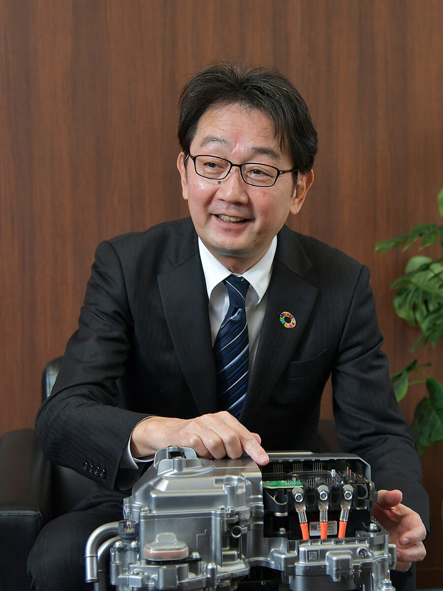 スーツとネクタイを着た人が機械のある机に座っている