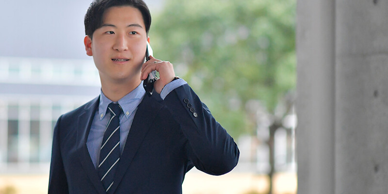 携帯電話を持ったスーツ姿の人