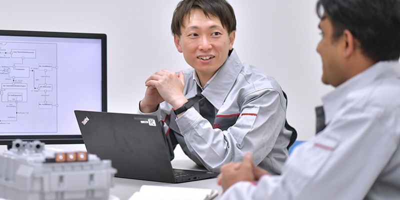 ノートパソコンを持ってテーブルに座っている人