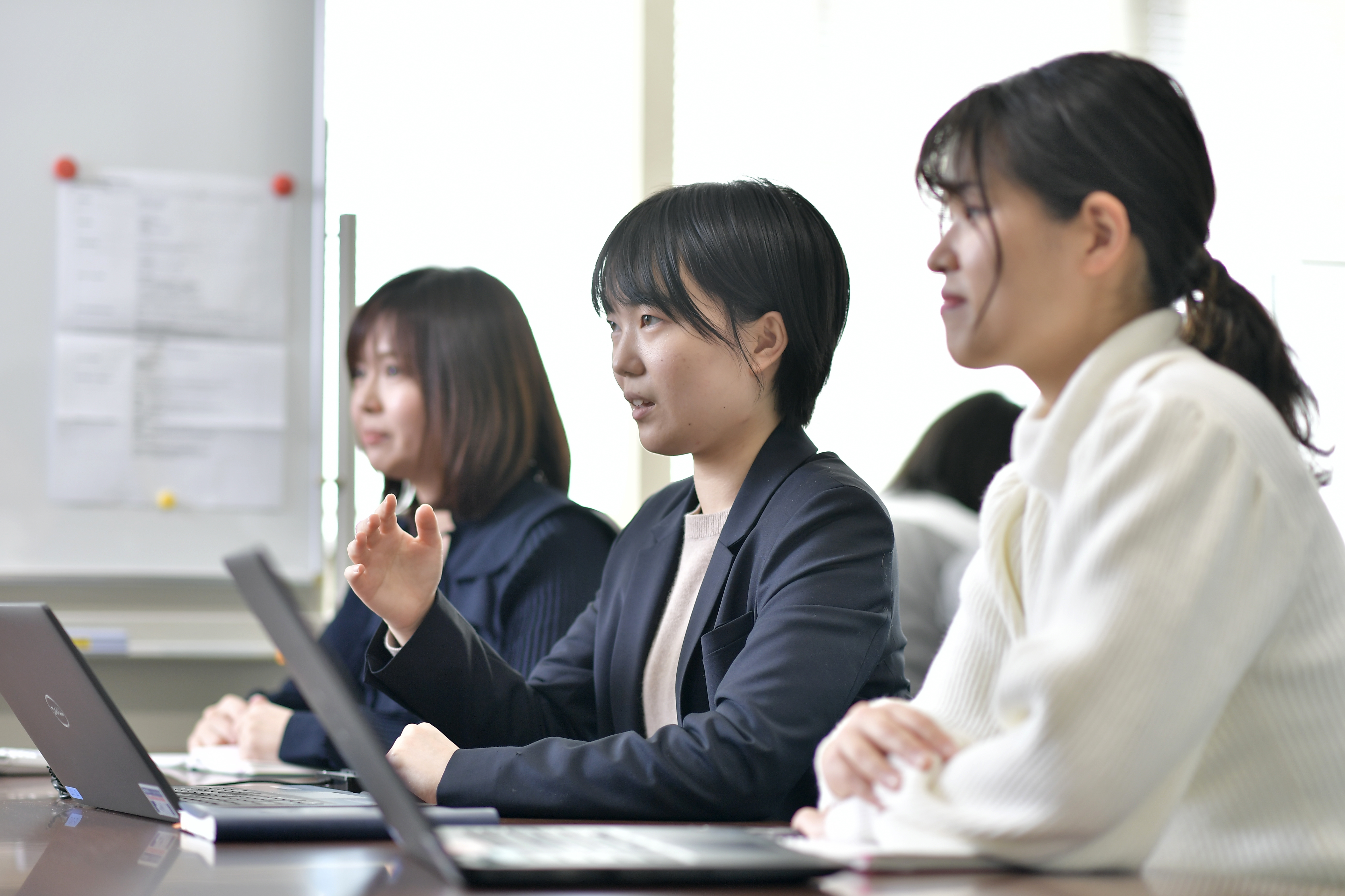 a group of women sitting at a table with laptops