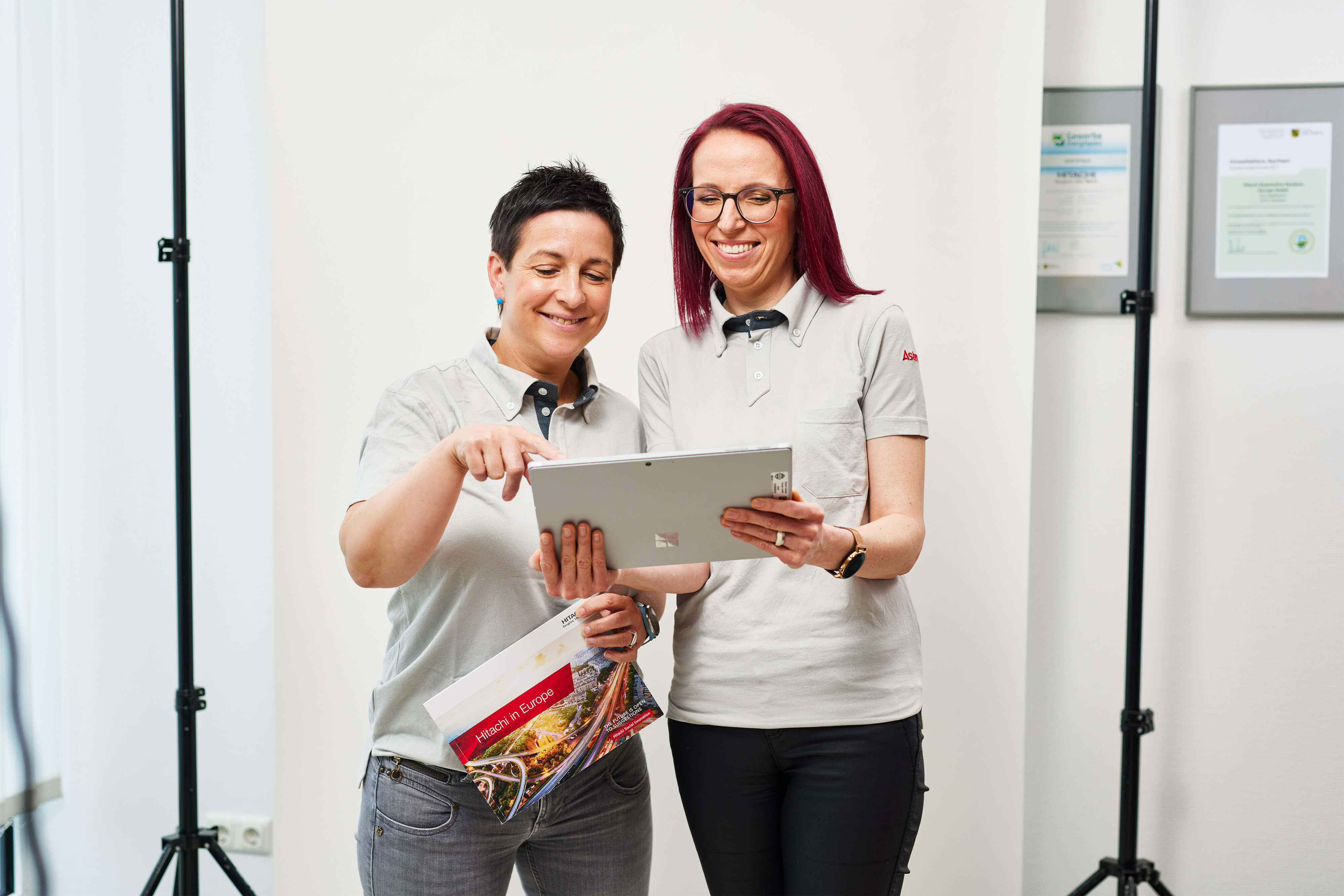 a couple of women looking at a tablet