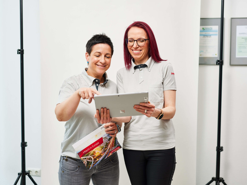 a couple of women looking at a tablet