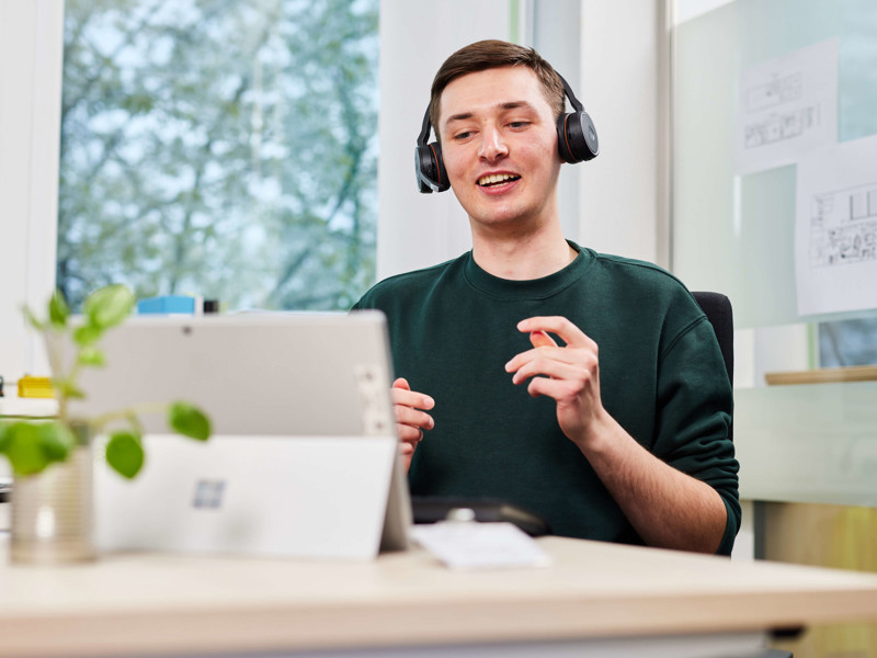 a person wearing headphones and sitting at a desk