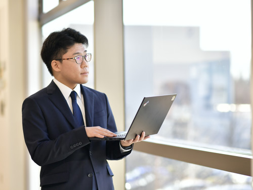ラップトップを持ったスーツを着た人