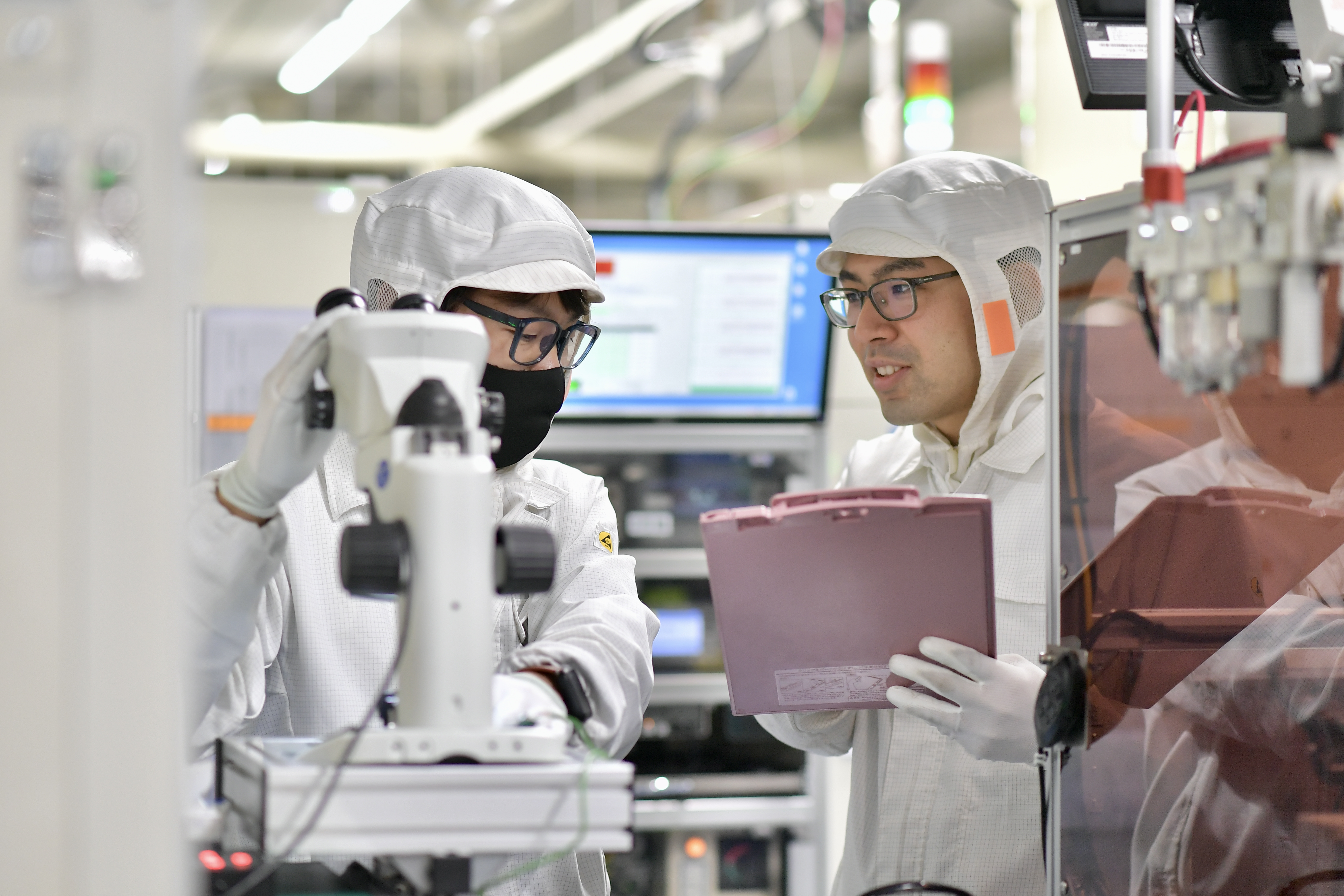 a person in white protective gear looking at a clipboard