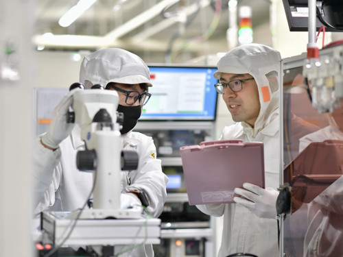 a person in white protective gear looking at a clipboard