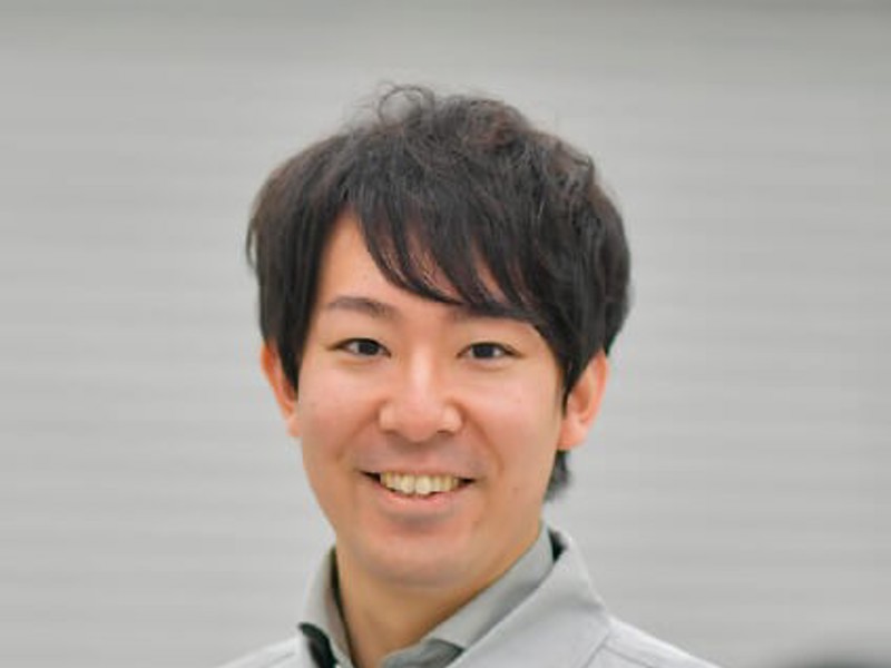 カメラに向かって笑顔を浮かべる人物