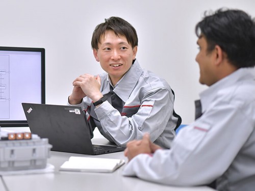 ノートパソコンを持ってテーブルに座っている人