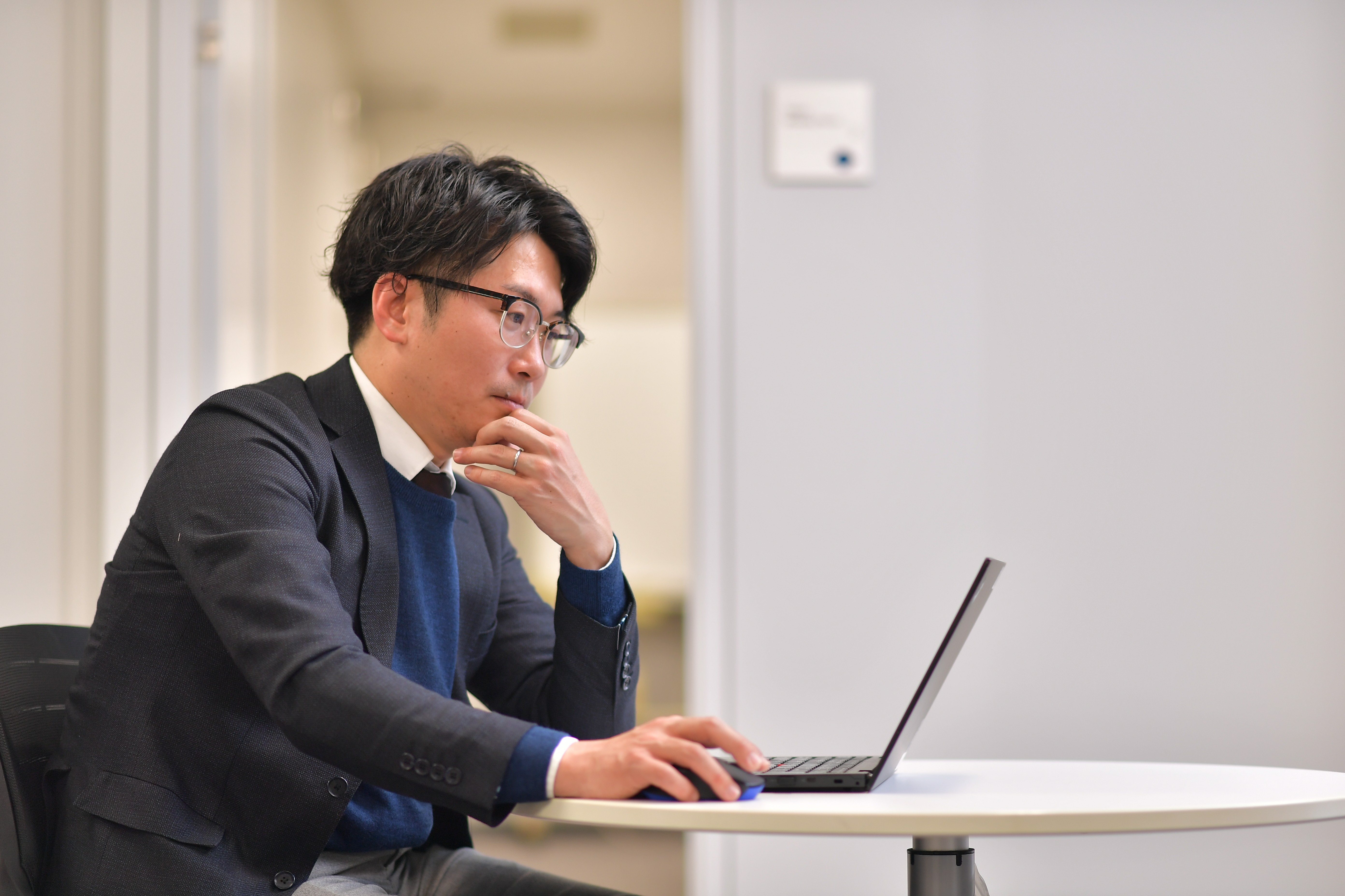 ノートパソコンを持ってテーブルに座っている人