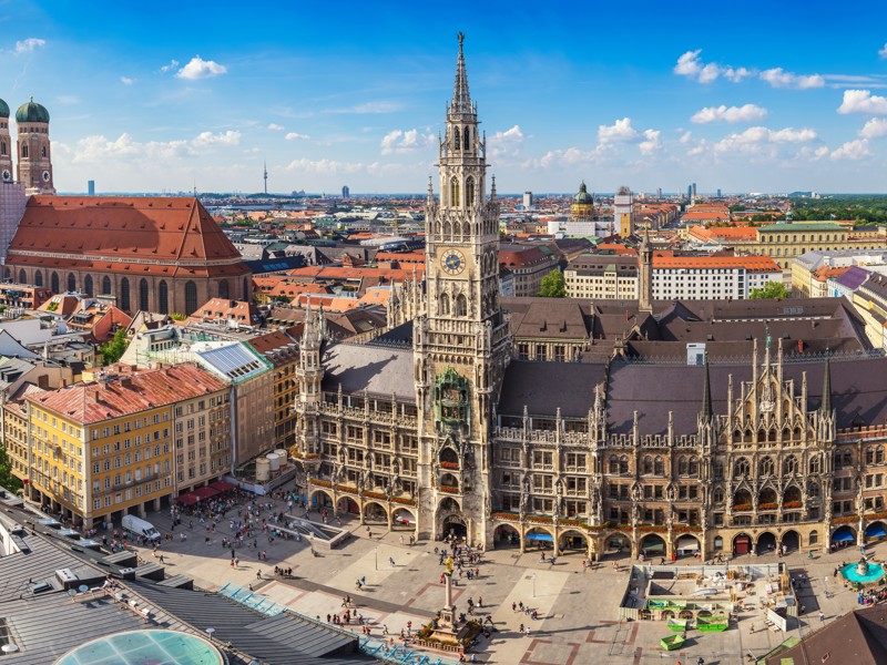 ein großes Gebäude mit einem Uhrenturm und einem Brunnen davor