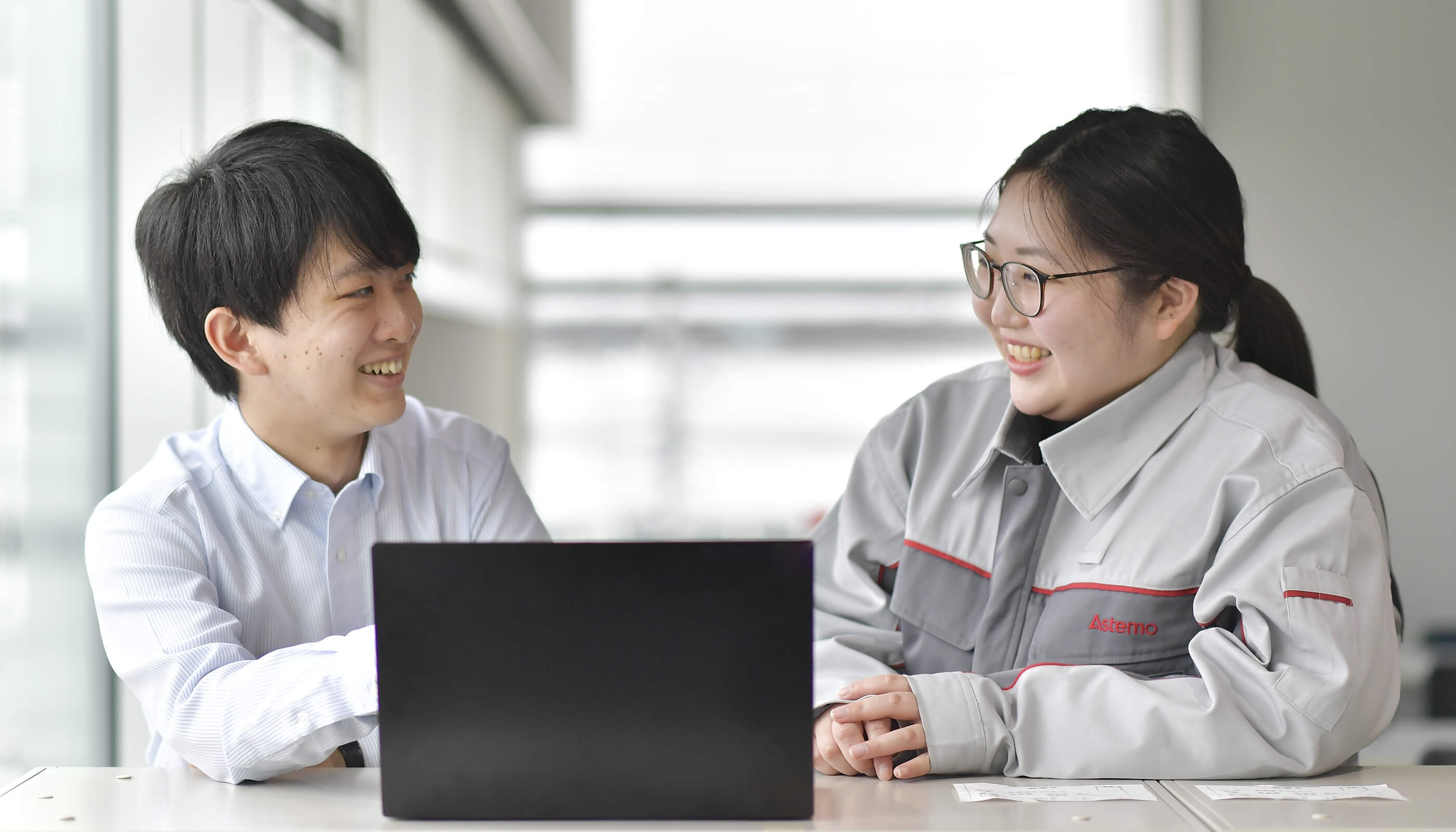 a person and person looking at a laptop
