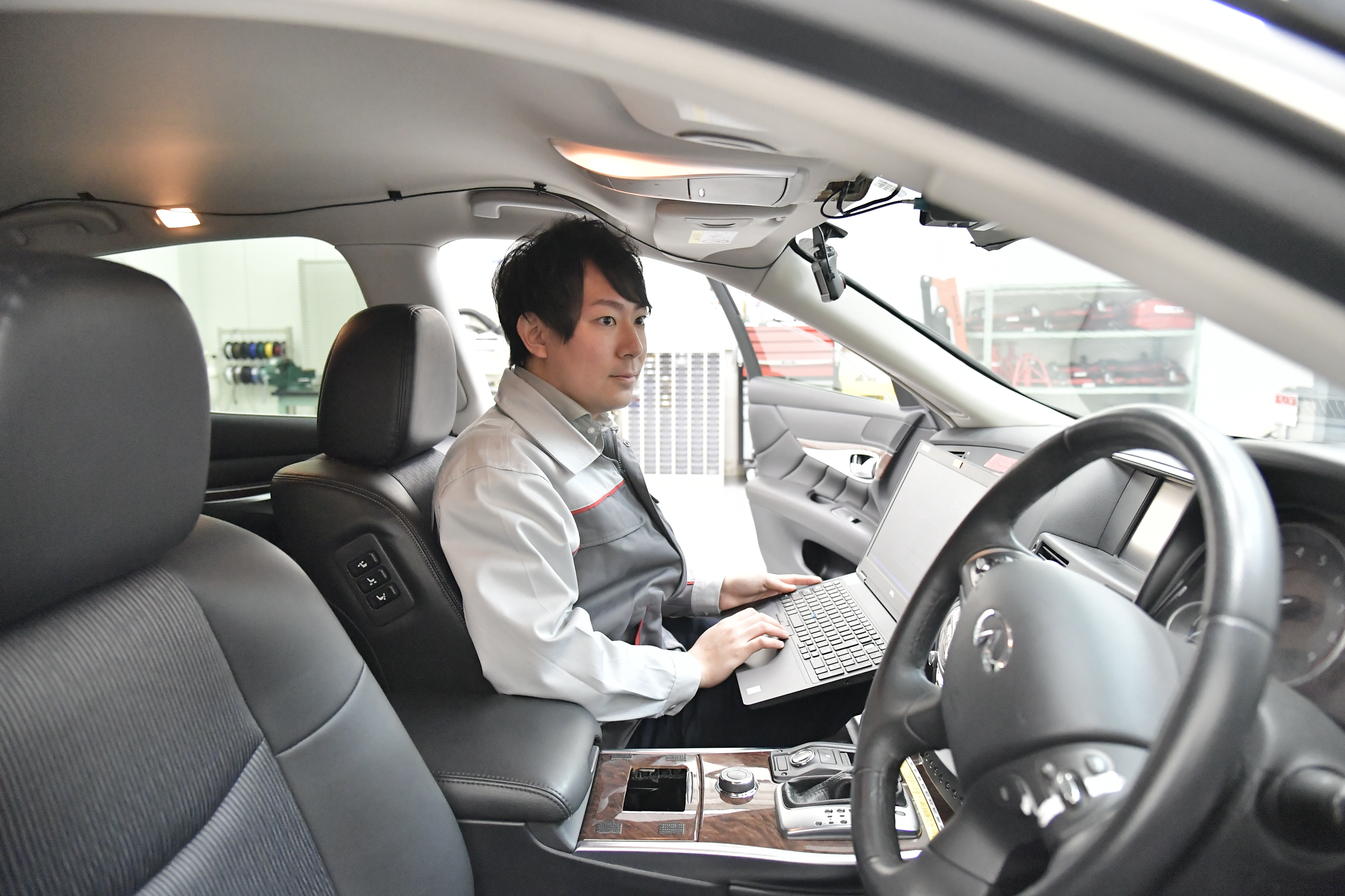 ラップトップを持って車に座っている人