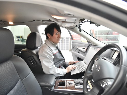 ラップトップを持って車に座っている人