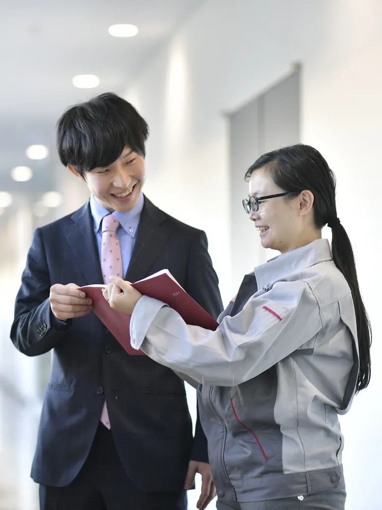 本を持って笑顔を浮かべる人と人