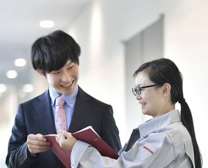 本を持って笑顔を浮かべる人と人