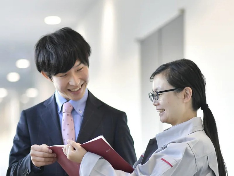 a person and person smiling while holding a book