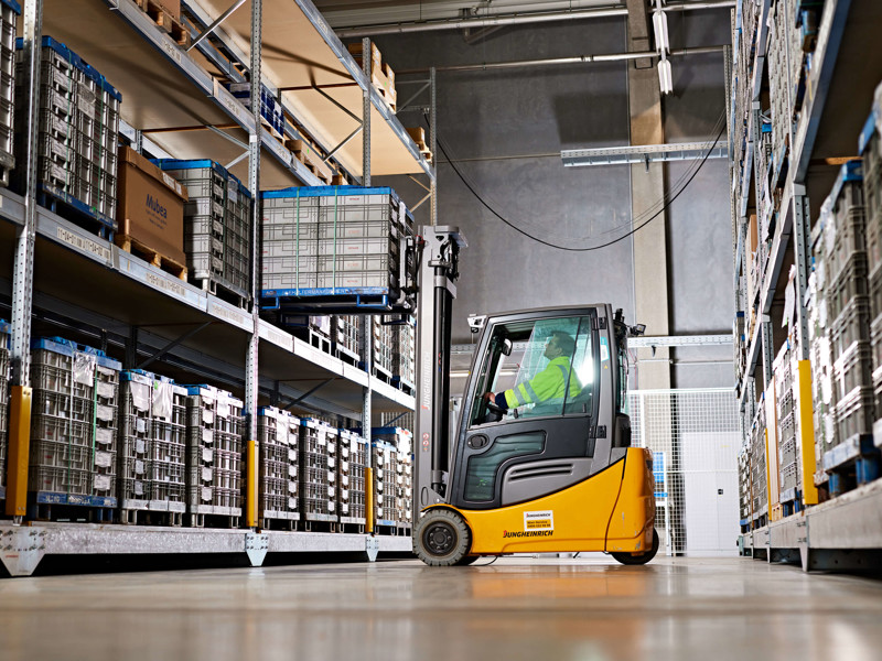 a person driving a forklift in a warehouse