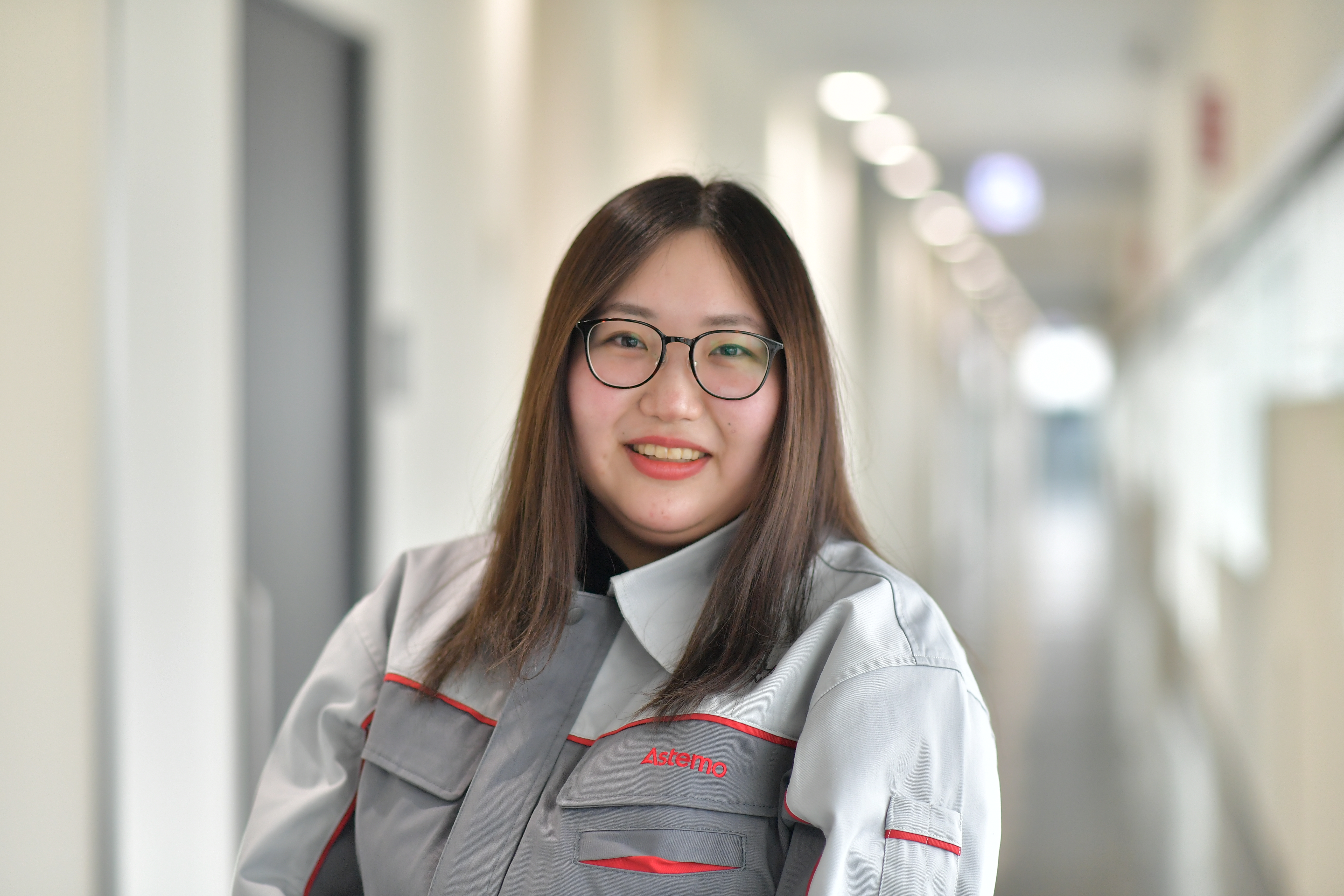 a person wearing glasses and a grey and white jacket